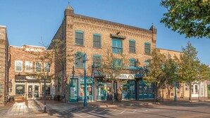 Un edificio storico con diversi negozi, tra cui un ristorante e una farmacia.