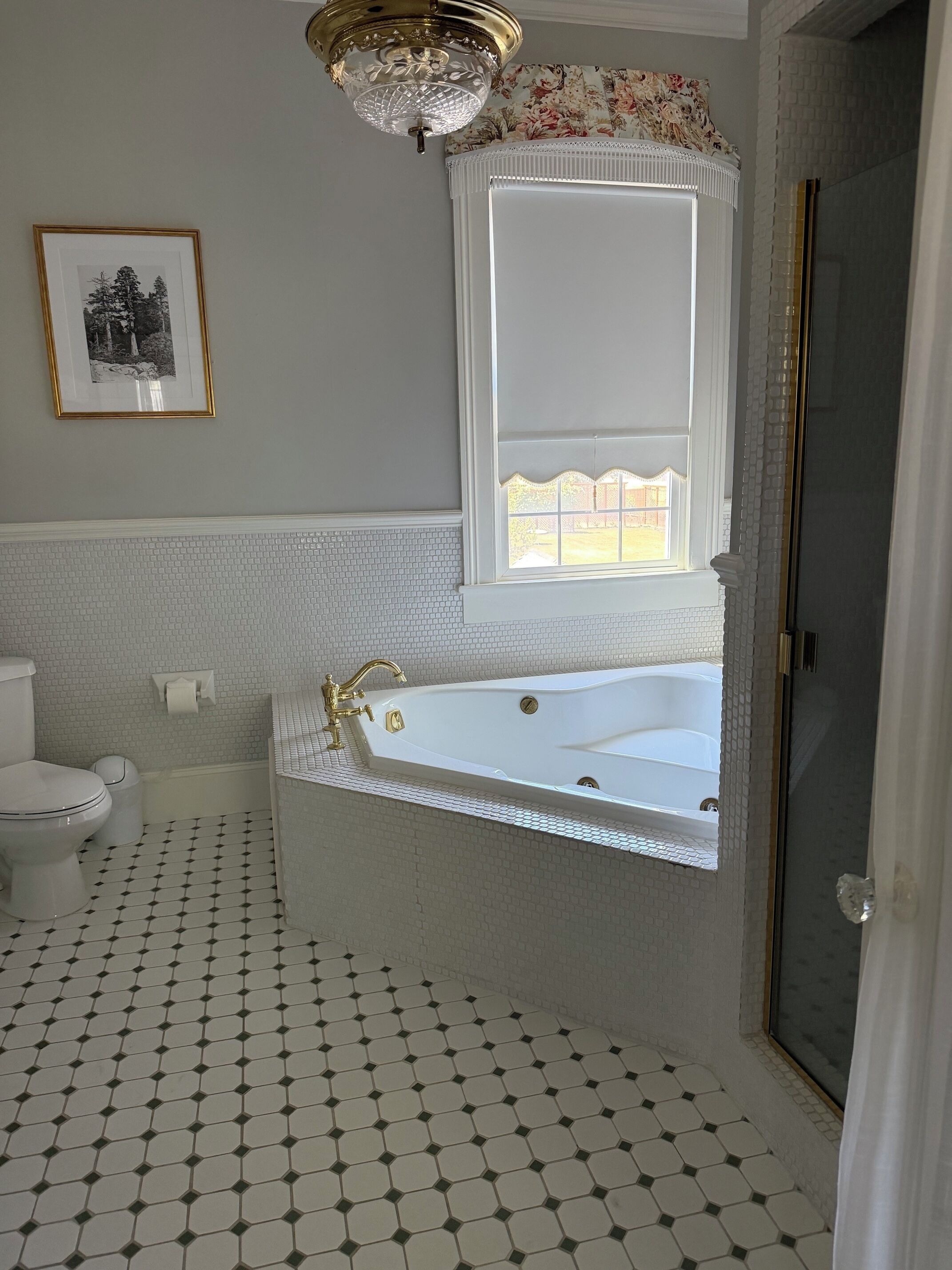 A bathroom with a white bathtub, a toilet, and a shower area.