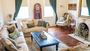 Una sala de estar tradicional con sofá, sillón, mesa de centro y chimenea.