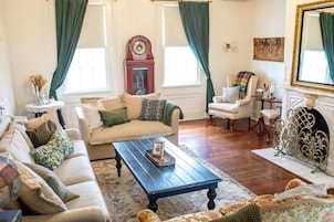 Una sala de estar tradicional con sofá, sillón, mesa de centro y chimenea.