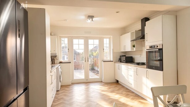 Una cocina moderna equipada con refrigerador, horno, microondas y un comedor con una silla y mesa.