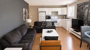 Una sala de estar moderna con sofá, mesa de centro y televisor.