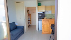 Um espaço compacto com cozinha compacta, sofá e área de refeições.