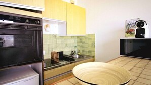 Uma cozinha com micro-ondas, pia e uma tigela sobre o balcão.