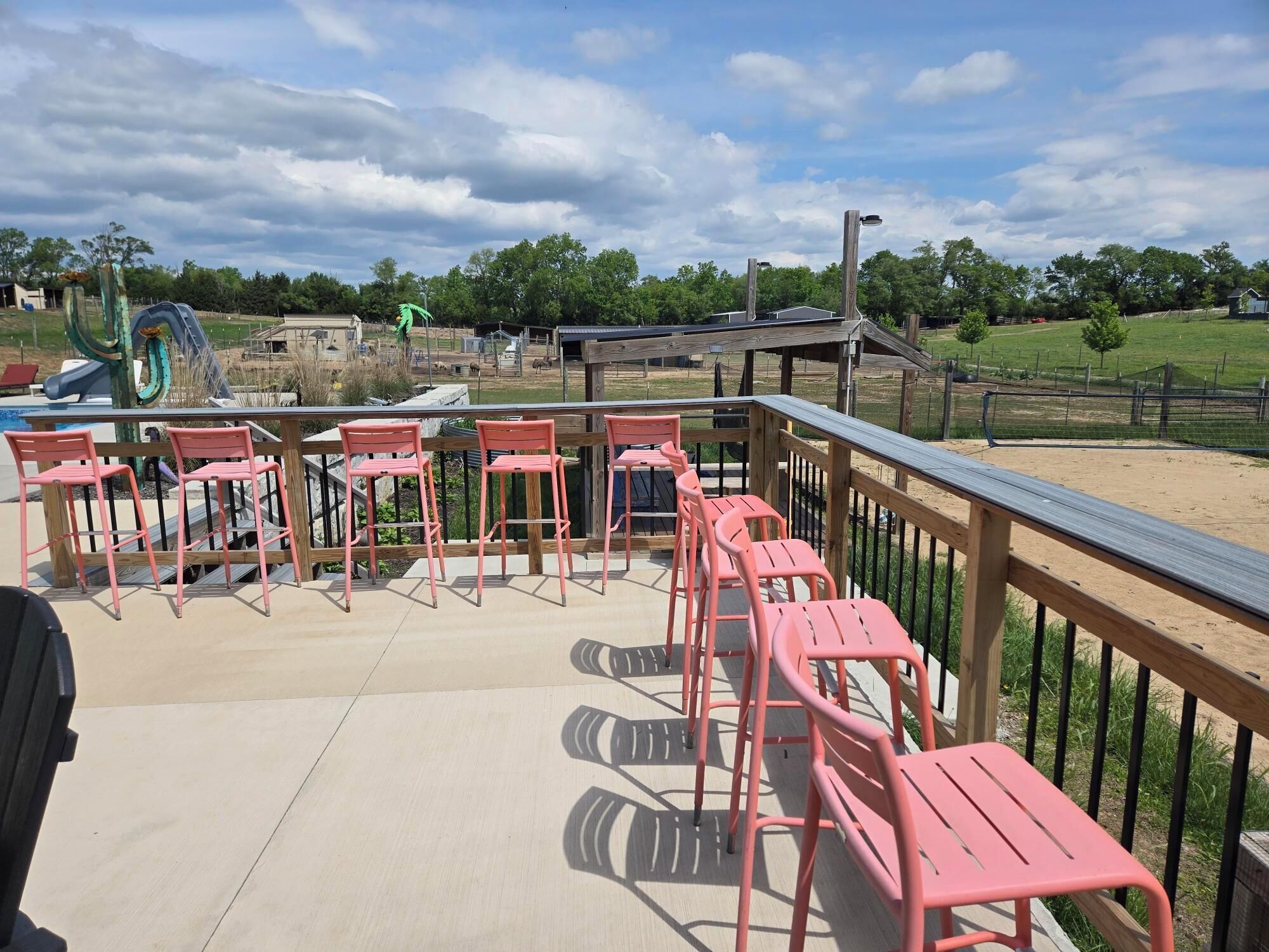 A deck with chairs and a view of a playground.