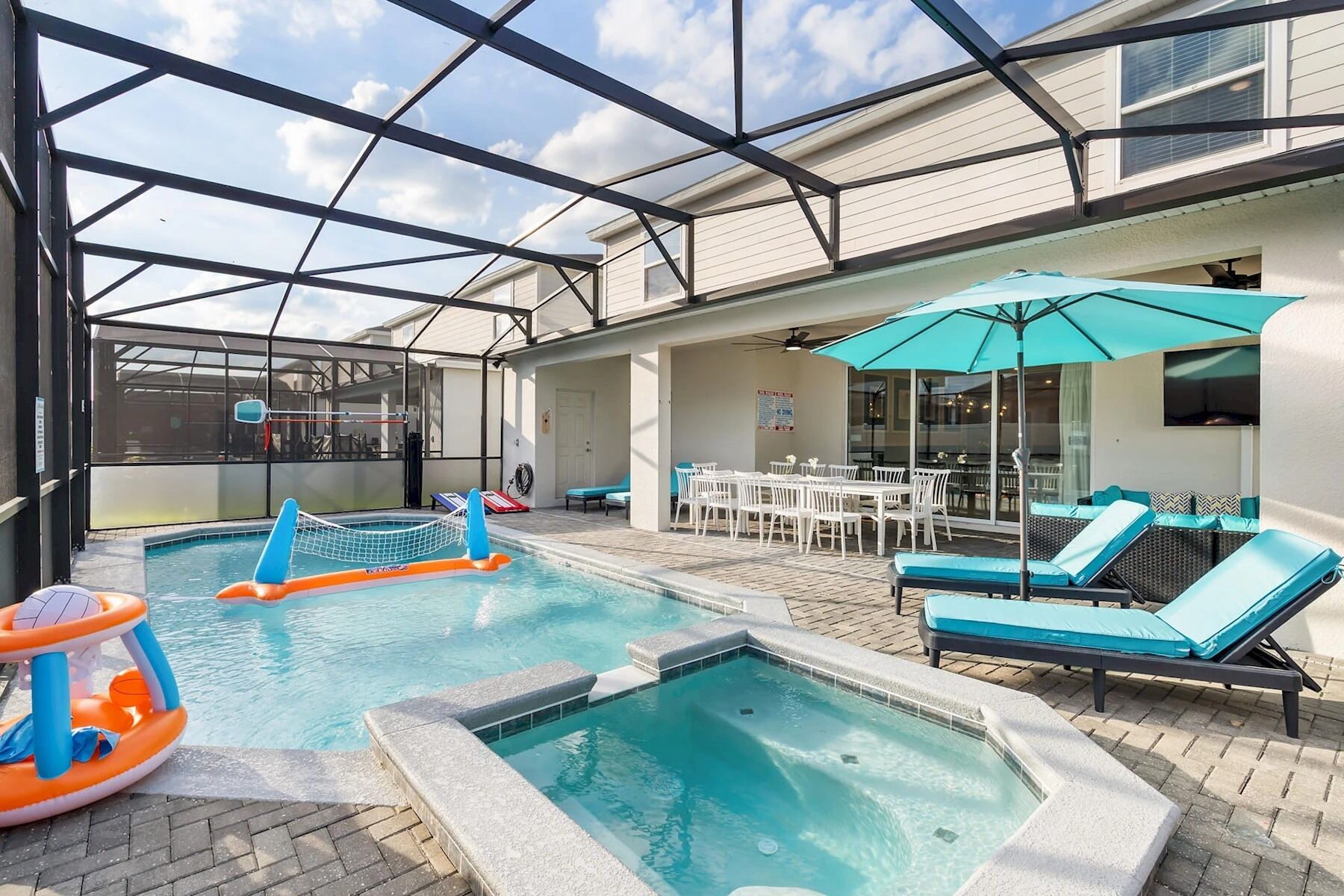 An indoor pool area with a hot tub, lounge chairs, and a covered seating area.