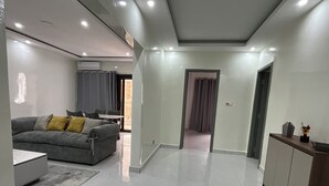 A modern living room with a grey sofa, a small table, and a cabinet. - 301: 2-bedroom apartment in quaint Dakar with AC for a relaxing stay (Dakar)