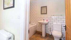 A bathroom with a white sink, a toilet, and a mirror. - Walnut Major (Kingsbridge)