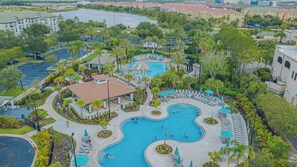 A resort with a central swimming pool, lounge areas, and a parking lot. - Spacious 3BR VistaCay Condo Near Disney, Universal & Orlando Attractions with Resort Amenities (Orlando)