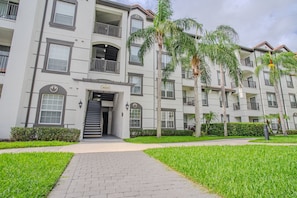 A multi-story residential building with a central entrance, balconies, and a well-maintained lawn. - Spacious 3BR VistaCay Condo Near Disney, Universal & Orlando Attractions with Resort Amenities (Orlando)
