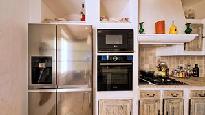 A kitchen with stainless steel appliances, a microwave, oven, and a gas stove. - CASA-Bouchra luxueux apt dans château provençal (Le Thoronet)