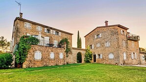 A two-story stone building with multiple windows and a central archway. - CASA-Bouchra luxueux apt dans château provençal (Le Thoronet)