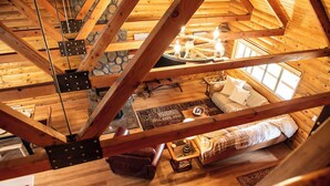 Un intérieur en bois avec un lit, une table et un mur en pierre.