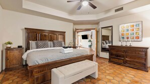 Makuuhuoneessa on puinen sänky, kattotuuletin, penkki, lipasto ja laatoitettu lattia.