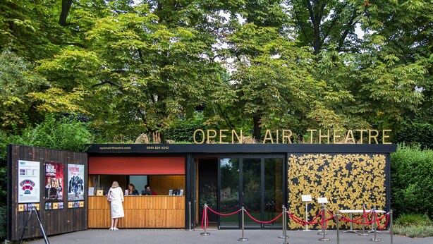 Een openluchttheater met een houten gevel, een receptiebalie en een glazen ingang.