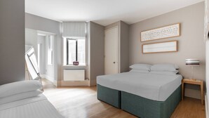 Een moderne slaapkamer met een groot bed, een raam met uitzicht en een nachtkastje.