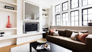 Een moderne woonkamer met een bank, salontafel en een flatscreen televisie.