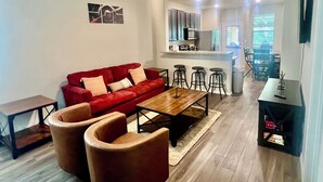 En moderne stue med en rød sofa, et træbord og en loftsvifte.