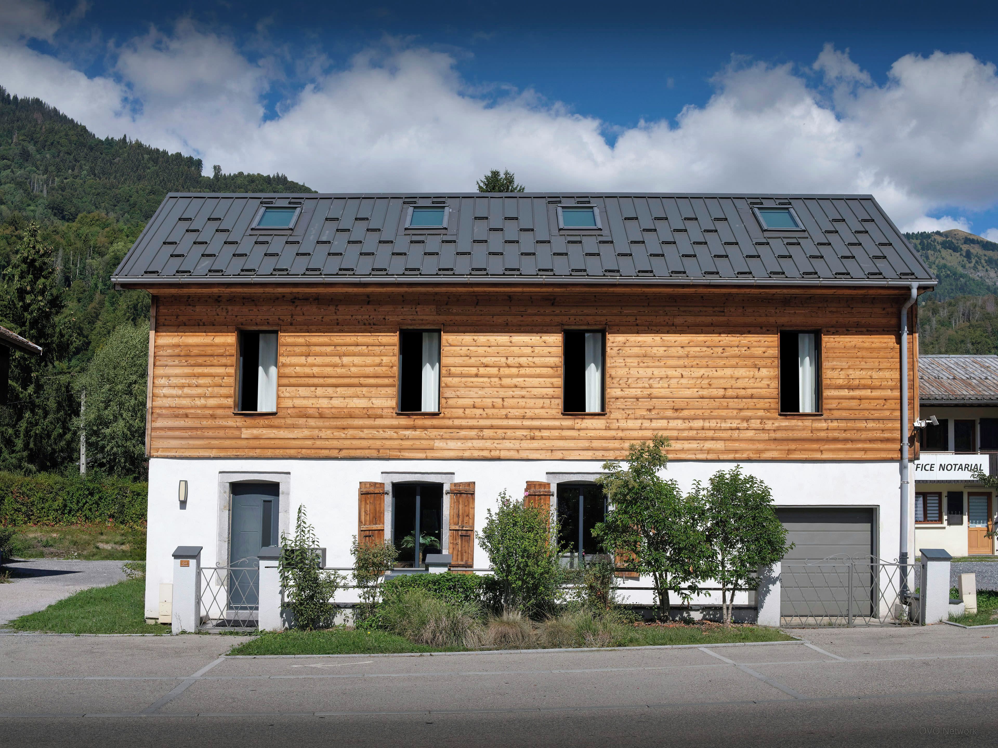 A two-story building with a sloped roof, wooden exterior, and multiple windows.