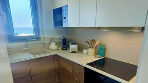 Una cocina moderna con lavavajillas integrado, ventana con vistas y armarios de madera.