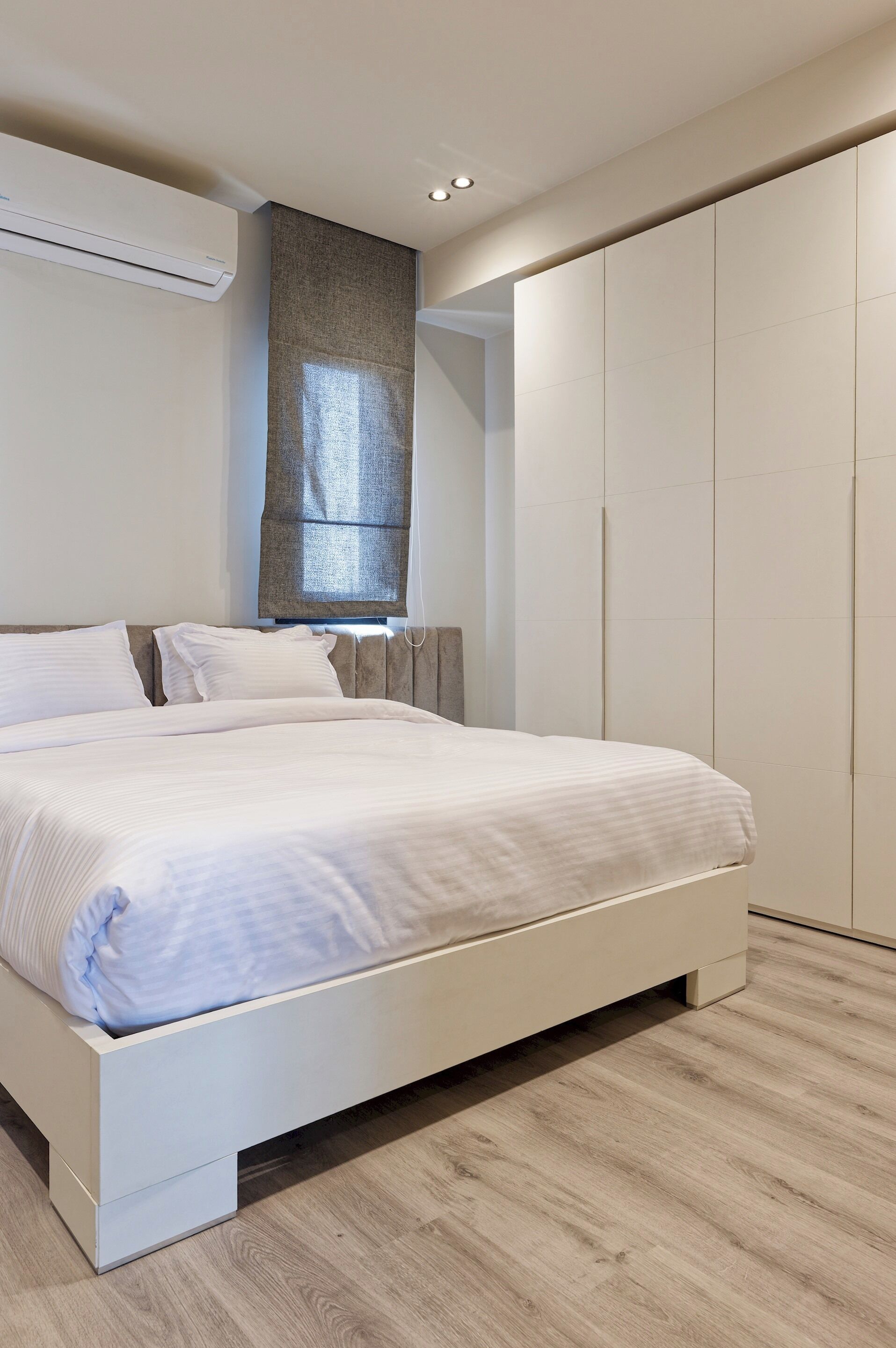 Une chambre à coucher comprenant un lit, une armoire et un appareil de climatisation.
