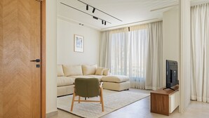 Un saló modern amb un sofà, un armari de fusta i una televisió.