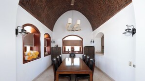 A dining area with a long wooden table, multiple chairs, and a brick ceiling. - VESTA - Luxury Villa - 4BR - North Golf (II) (El Gouna)