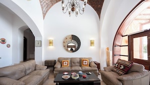 A spacious living room with high ceilings, a chandelier, and a large mirror. - VESTA - Luxury Villa - 4BR - North Golf (II) (El Gouna)