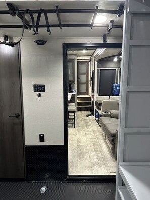 Un interior funcional con kitchenette, zona de estar y una pequeña mesa.