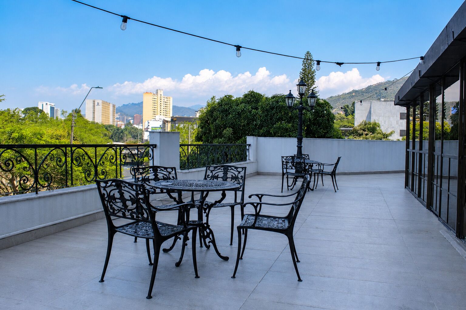 A rooftop terrace with outdoor furniture and string lights.
