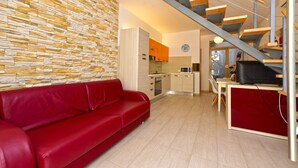 Ein modernes Interieur mit einem roten Sofa, einer Küche und einer Treppe.