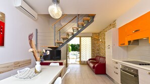 Una cocina moderna con comedor, una escalera y un sofá rojo.