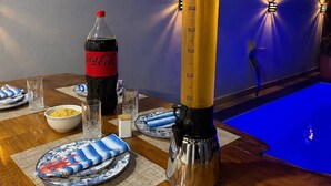 Eine Bar mit Zapfhahn, einer Coca-Cola Flasche und einem Billardtisch.