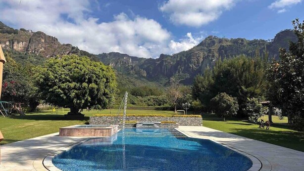 A swimming pool with a view of mountains and trees.