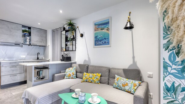 A modern living space with a kitchenette, a sofa set, a dining table, and a decorative lamp. - Le Jardin du Littoral - Welkeys (Bandol)