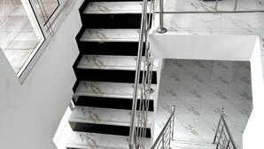 Eine moderne Treppe mit Marmorboden und Metallgeländern.