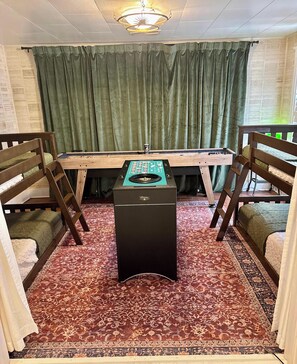 A room with a foosball table, two bunk beds, a desk, and a patterned carpet. - Ten33 | Luxe Sayles District Experience, King Bed! (Abilene)