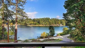 A lake surrounded by trees, a road, and a building in the background. - Charming 3-bedroom house in enjoyable Gig Harbor with AC (Gig Harbor)