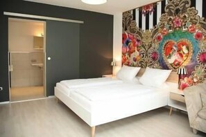 Ein Schlafzimmer mit einem Bett, einem Nachttisch, einer Lampe und einer dekorativen Wandteppich.