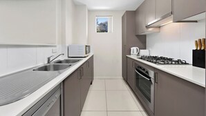 Une cuisine moderne équipée d’un four à micro-ondes, d’un évier, d’une cuisinière et d’un four.