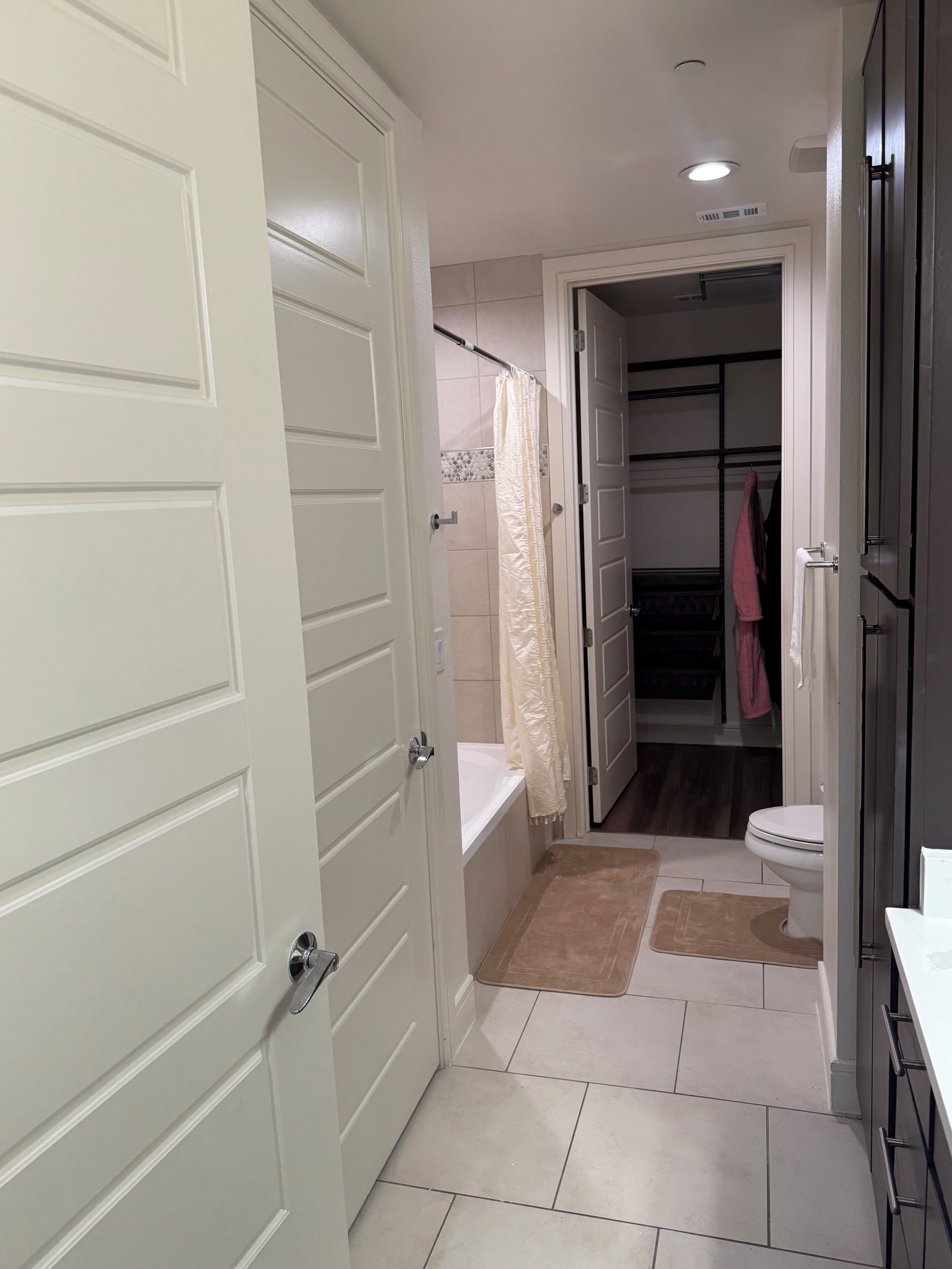 A bathroom with a bathtub, toilet, and a shower curtain.