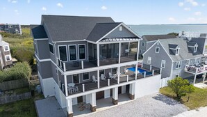 Une maison à deux étages avec un balcon, une piscine et une vue sur la mer.