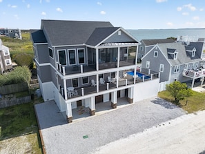 Ein zweistöckiges Haus mit Balkon, Schwimmbad und Meerblick.