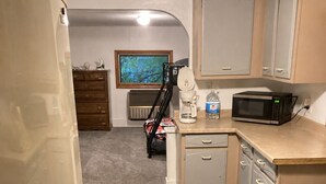A compact kitchen with a microwave, coffee maker, and a small refrigerator.