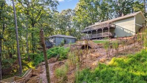 A cabin with a deck and stairs leading to a covered porch. - Lake Home with private dock (Gainesville)