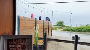 A framed quote on a table, a wooden fence, and a view of the beach through a window.