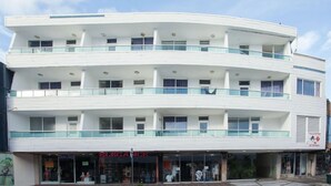 A multi-story building with a modern design, featuring balconies and large windows.