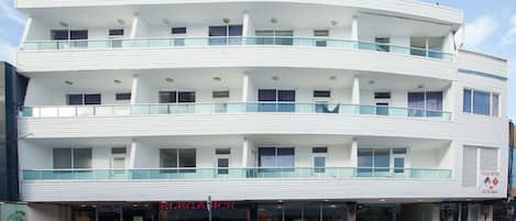 A multi-story building with a modern design, featuring balconies and large windows.