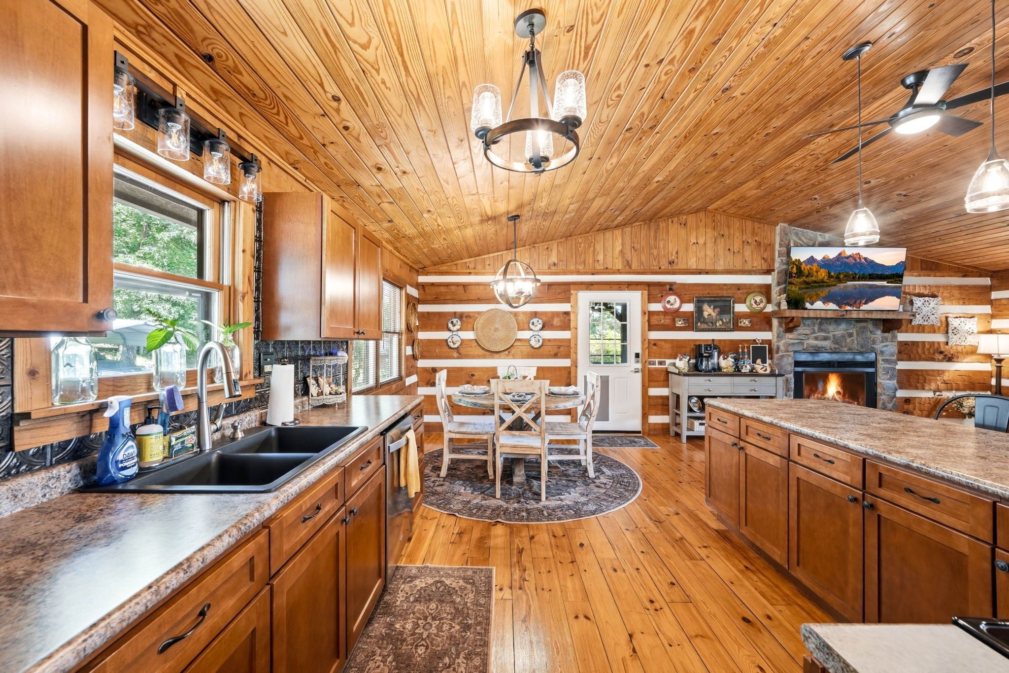Un intérieur en bois comprenant une cuisine, un coin repas et une cheminée.
