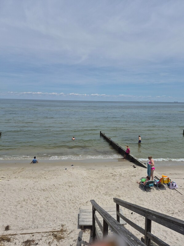 A beach with a wooden pier extending into the water, a sandy shore, and a few people in the distance. - Superb 3-bedroom mobile home with AC in Heathsville (Heathsville)
